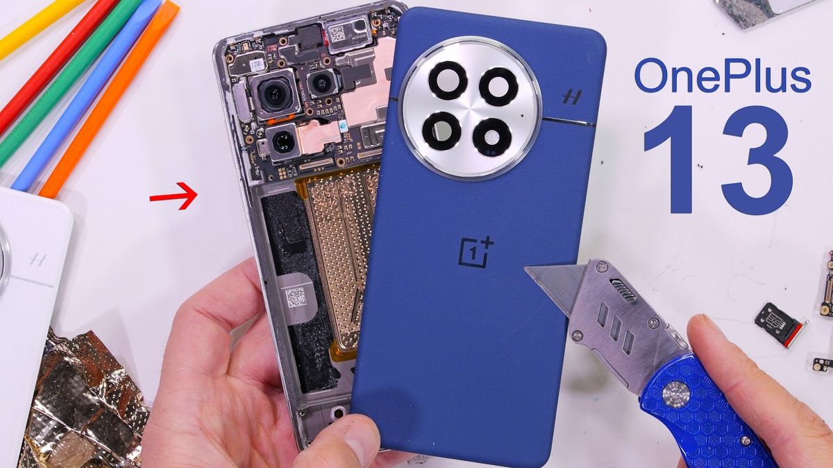 Thumbnail image showing a close-up of the OnePlus 13 smartphone partially disassembled, revealing its intricate double-decker cooling system. The phone is placed on a clean white surface with various small tools and components scattered around, highlighting the teardown process. The text overlay reads "OnePlus 13 Teardown" in bold letters.