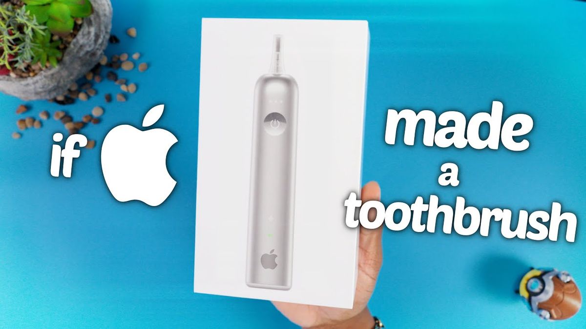 A sleek, metallic toothbrush with a minimalist design resembling a MacBook, displayed on a clean, white surface with a blurred background.